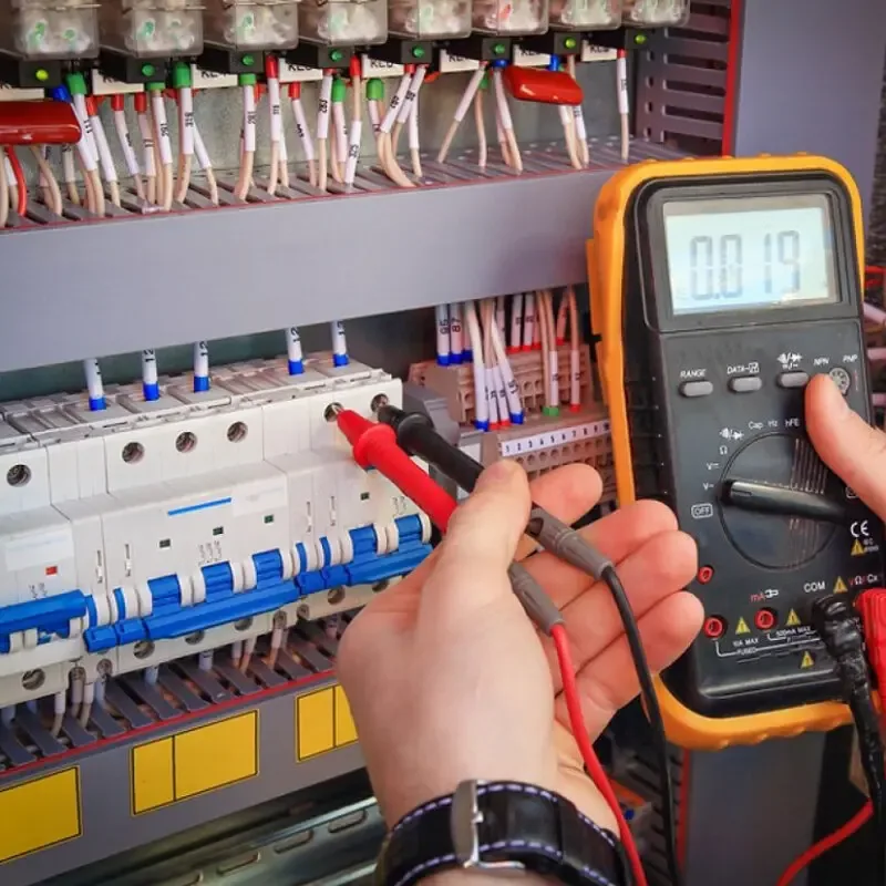 Electrician testing a switchboard with a multimeter
