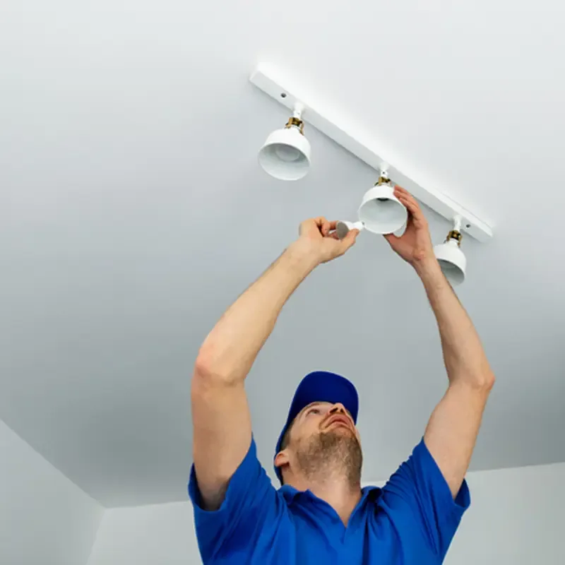 Electrician fitting a ceiling light